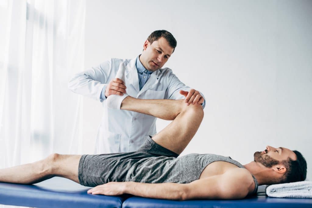 Chiropractor treating a patient's hip and knee.