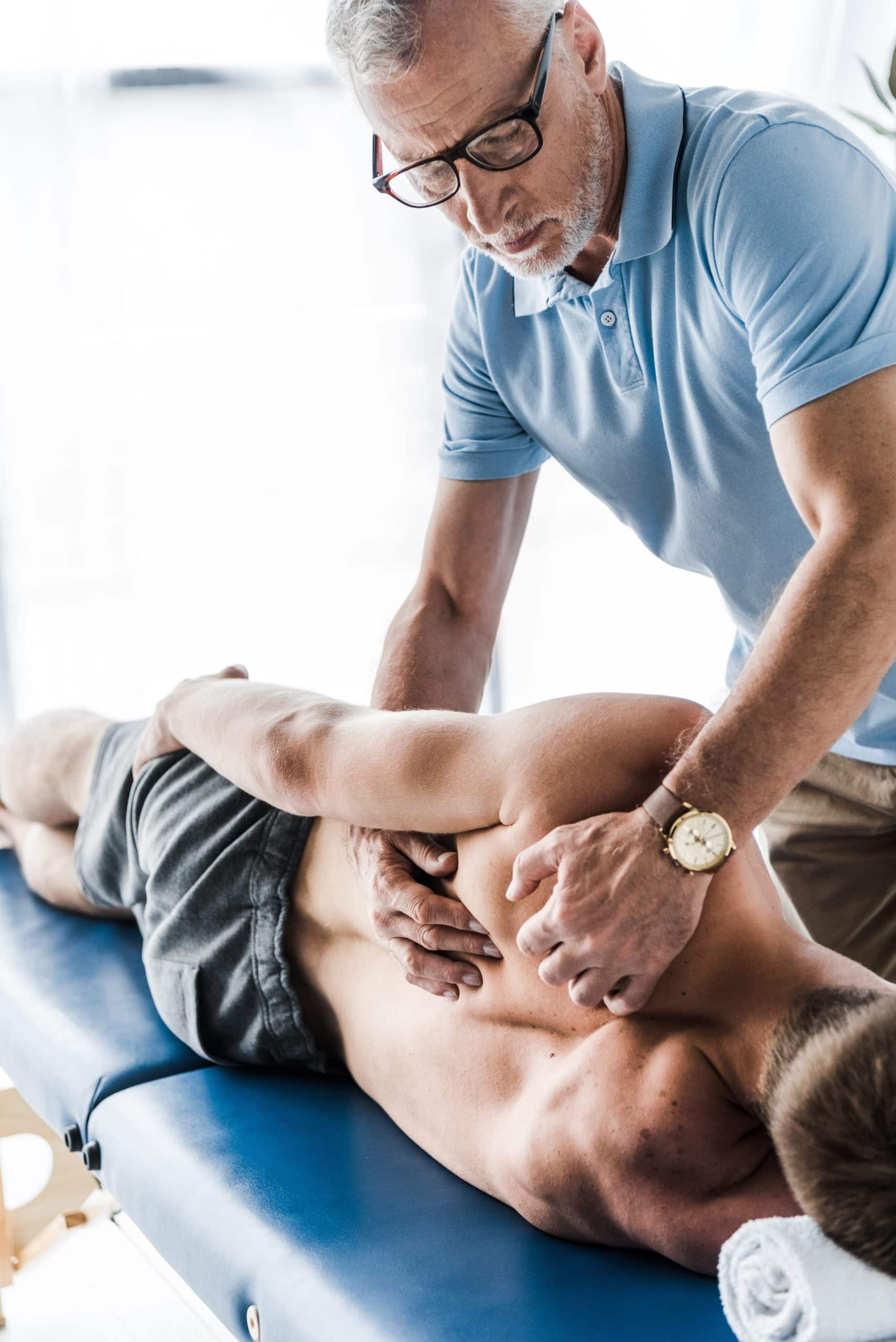 Chiropractor performing a spinal adjustment on a patient.