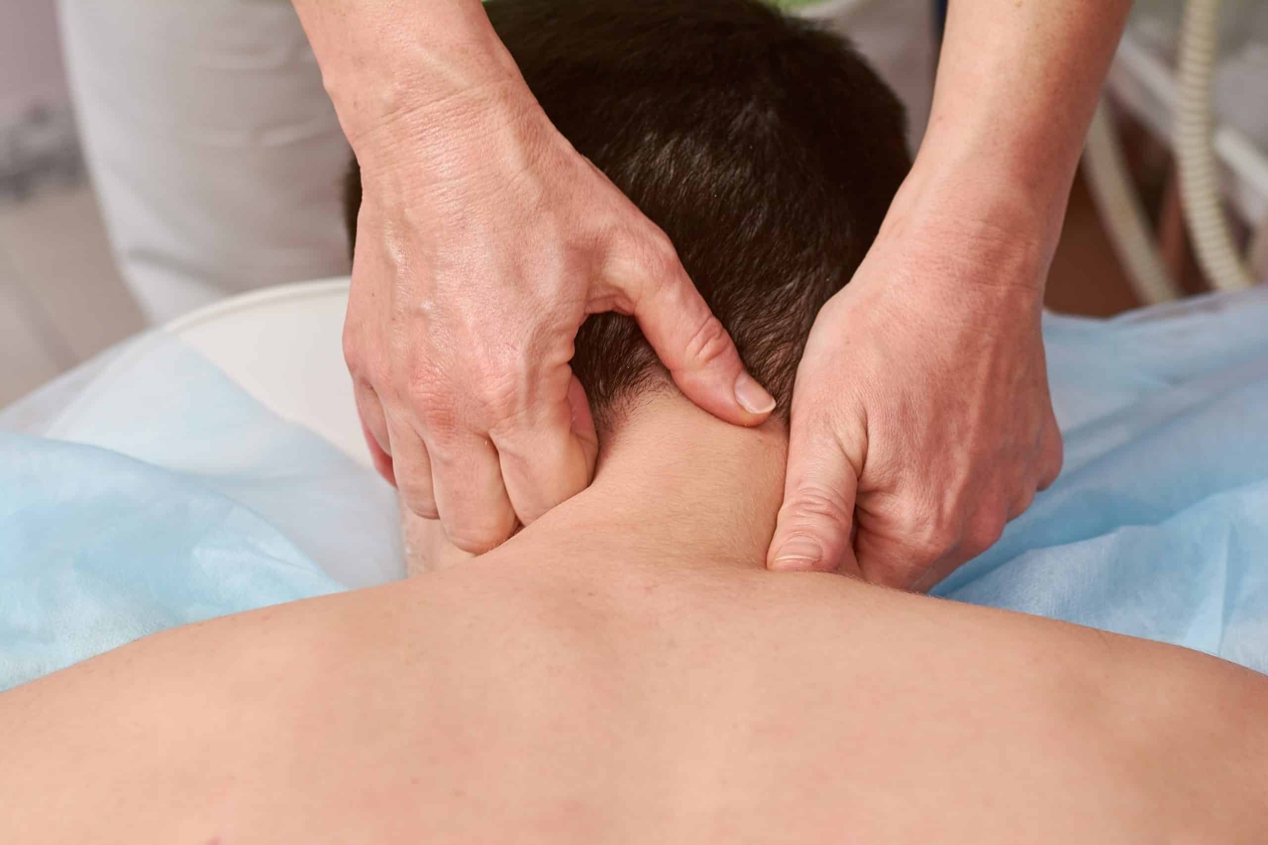 Patient receiving neck treatment from chiropractor.
