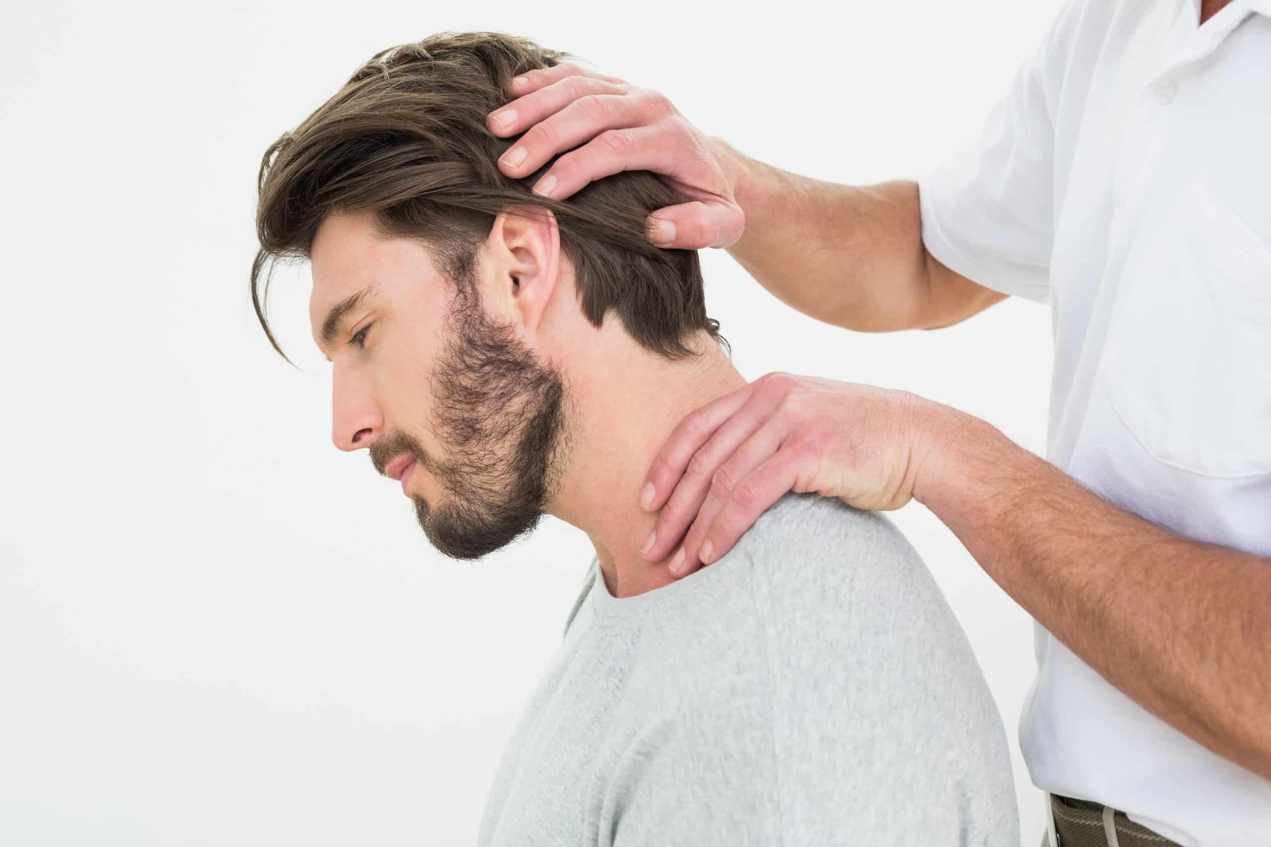 Side view of a young man getting a chiropractic neck treatment