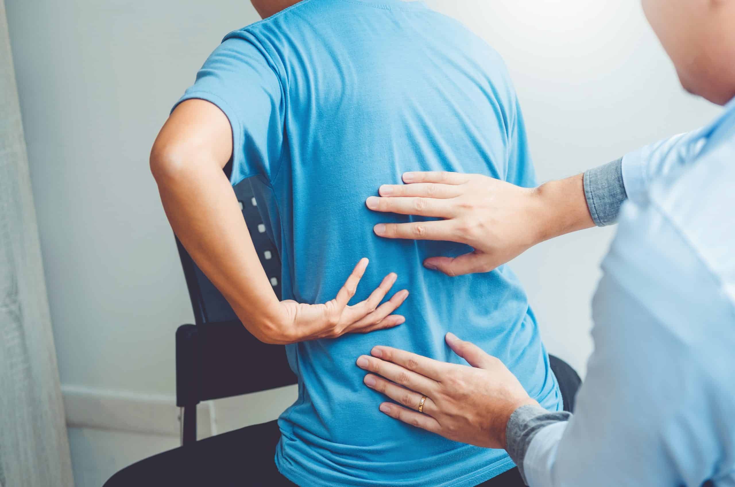 Chiropractor consulting a patient with back pain